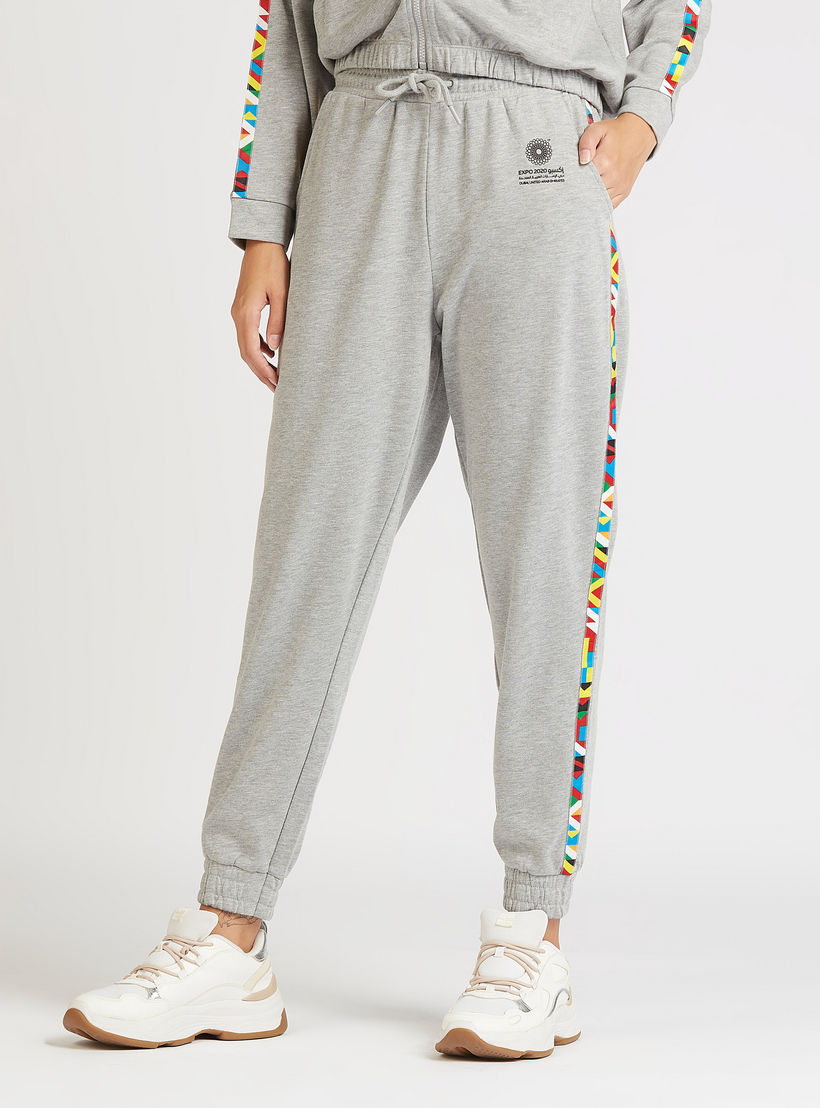 بنطلون رياضي بارز الملمس بخصر مرتفع بتفاصيل شريط بطبعات من إكسبو 2020-women-clothing-bottoms-joggers-image-1