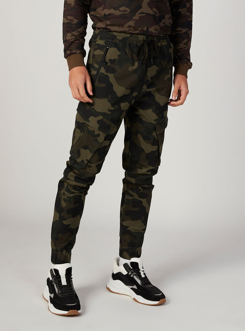 بنطلون رياضي بخصر مطّاطي متوسط الارتفاع وطبعات مموهّة-men-clothing-bottoms-joggers-image-1