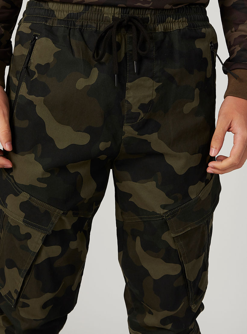 بنطلون رياضي بخصر مطّاطي متوسط الارتفاع وطبعات مموهّة-men-clothing-bottoms-joggers-image-3