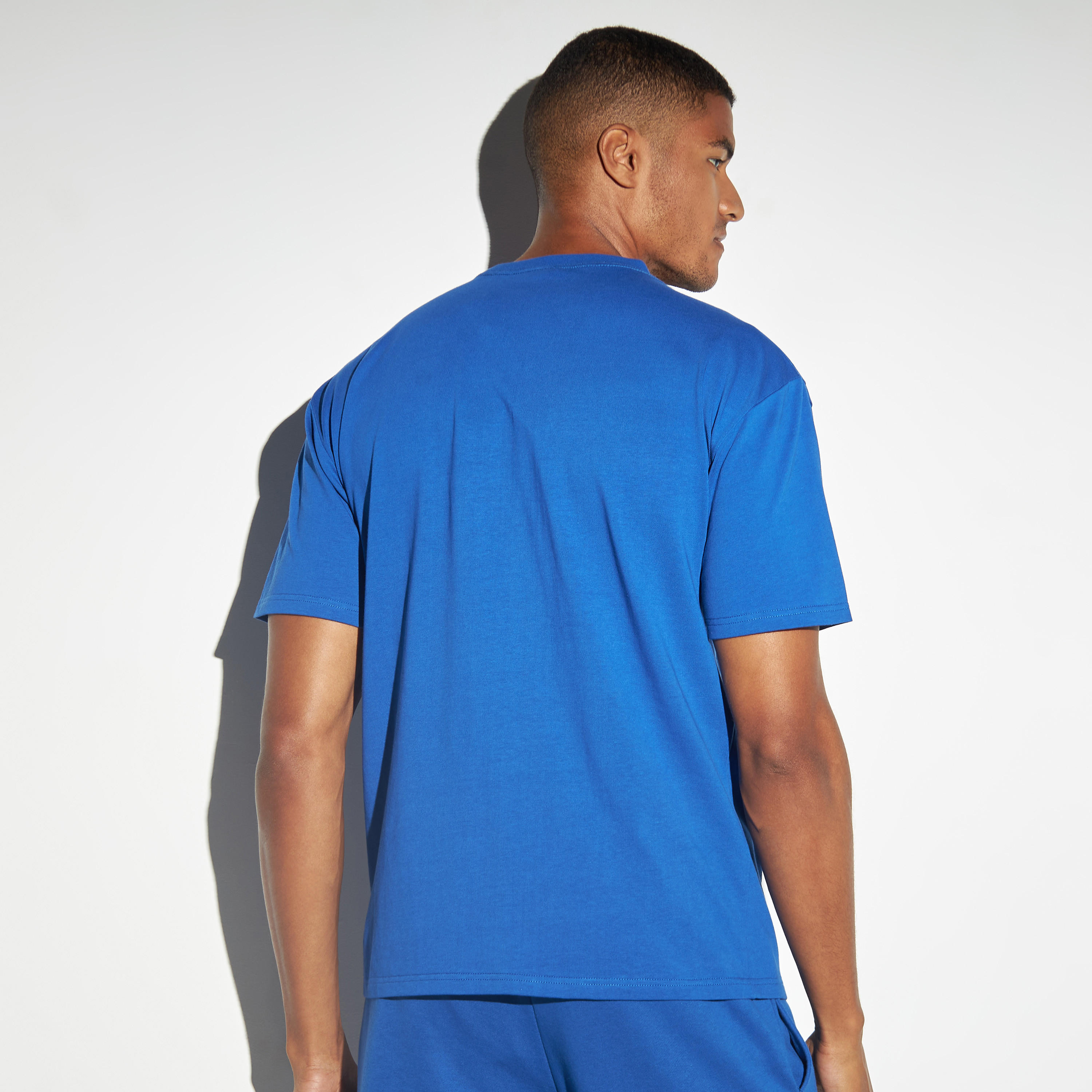 تيشيرت فضفاض بأكمام قصيرة وياقة ضيقة وطبعات شعار من كابا-men-clothing-sportswearandactivewear-tshirtsandpolos-image-3