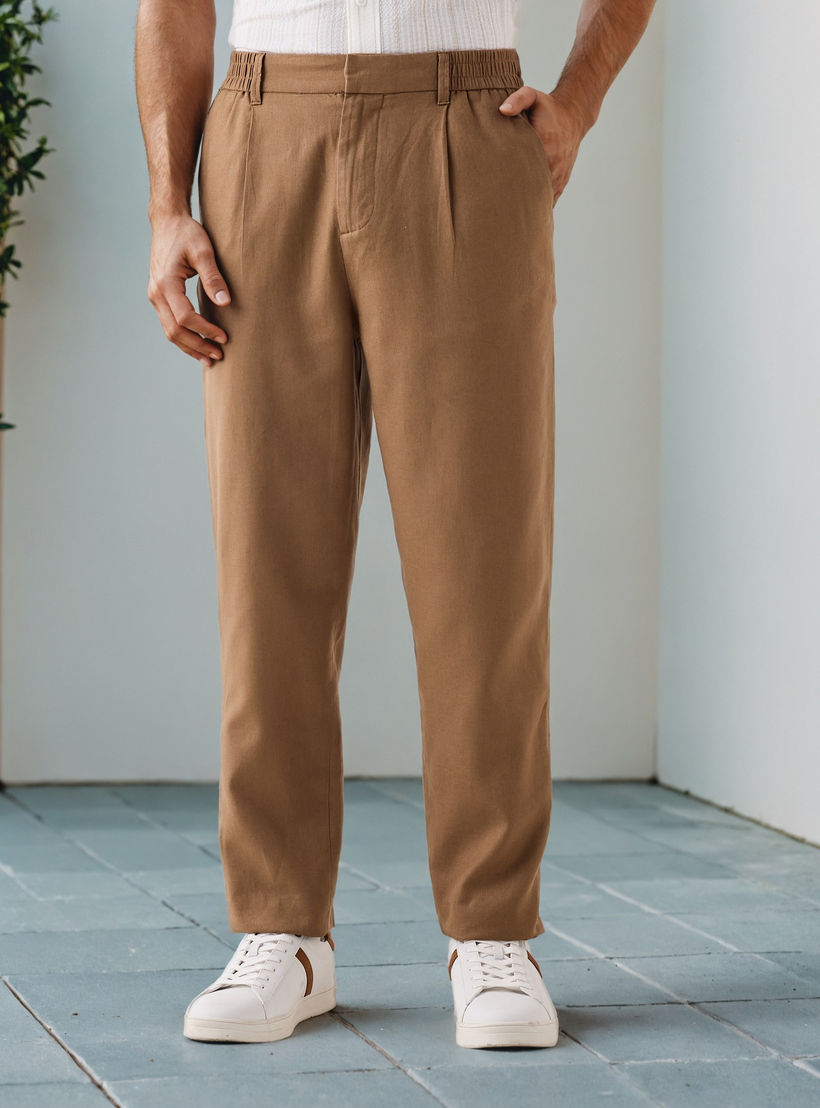 بنطلون كتان بكسرات وقصة مريحة وخصر مرن-men-clothing-bottoms-trousersandchinos-trousers-image-1