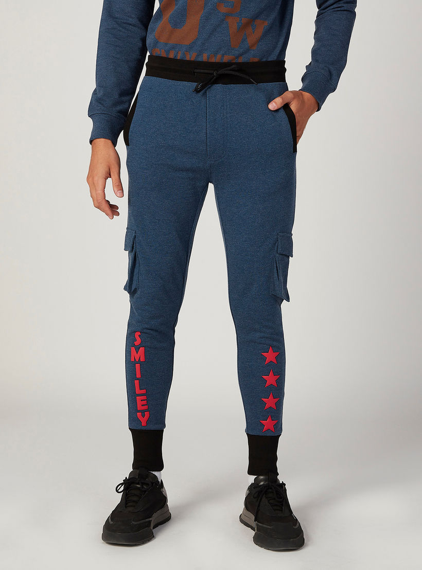 بنطلون رياضي مستدام سليم بخصر منخفض الارتفاع وطبعات سمايلي وورلد-men-clothing-bottoms-joggers-image-1
