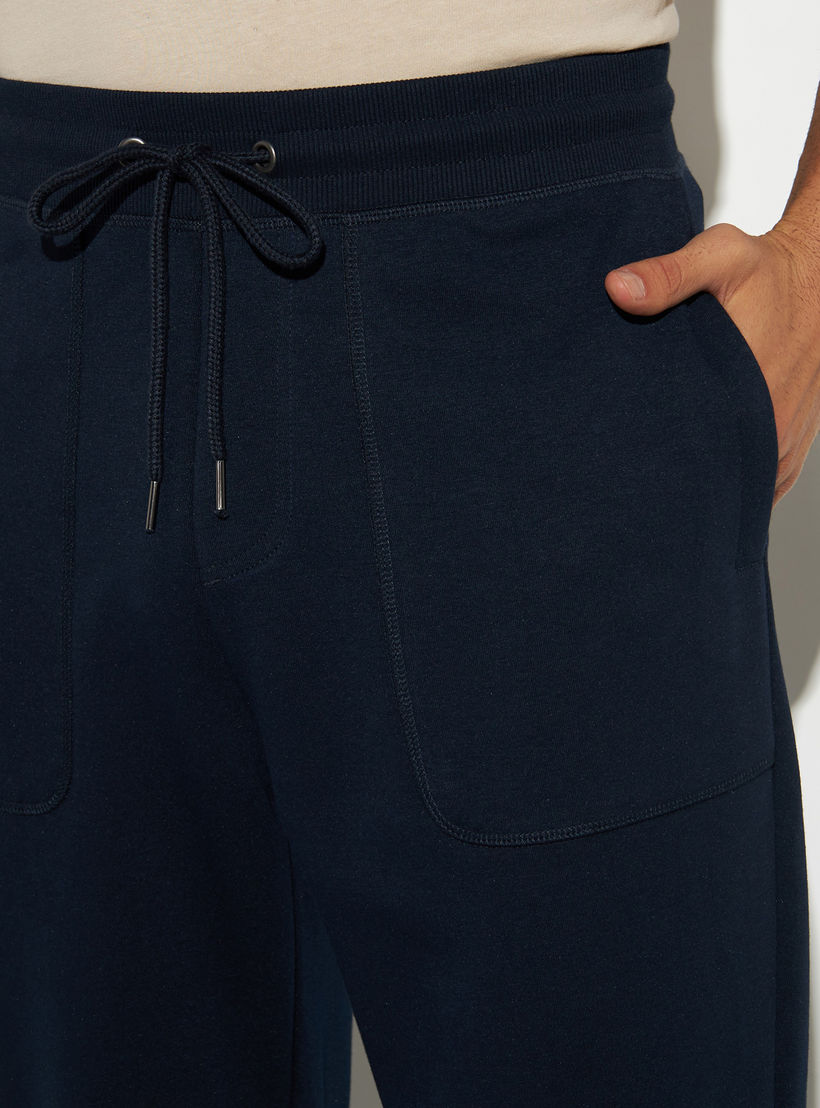 بنطلون رياضي سادة بقصّة مريحة ورباط إغلاق وجيوب-men-clothing-bottoms-joggers-image-1