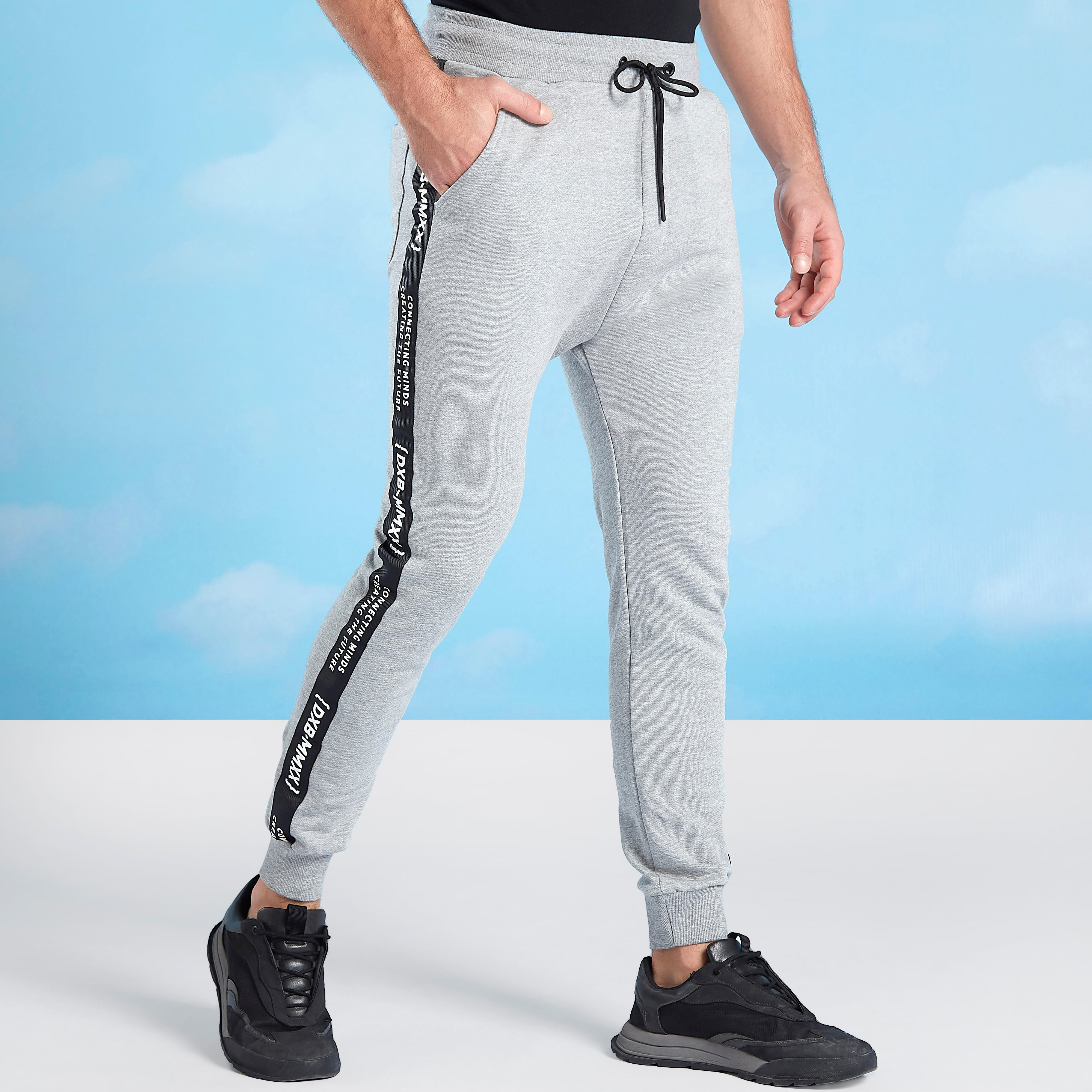 بنطلون رياضي سكيني بخصر متوسط الارتفاع وطبعات إكسبو 2020-men-clothing-bottoms-joggers-image-1