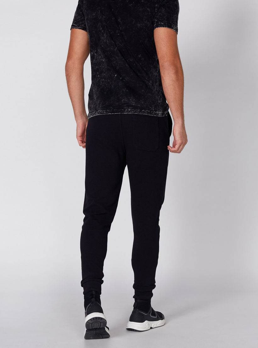 بنطال رياضي طويل بخصر مطّاطي وطبعات بيينج هيومن-men-clothing-bottoms-joggers-image-5